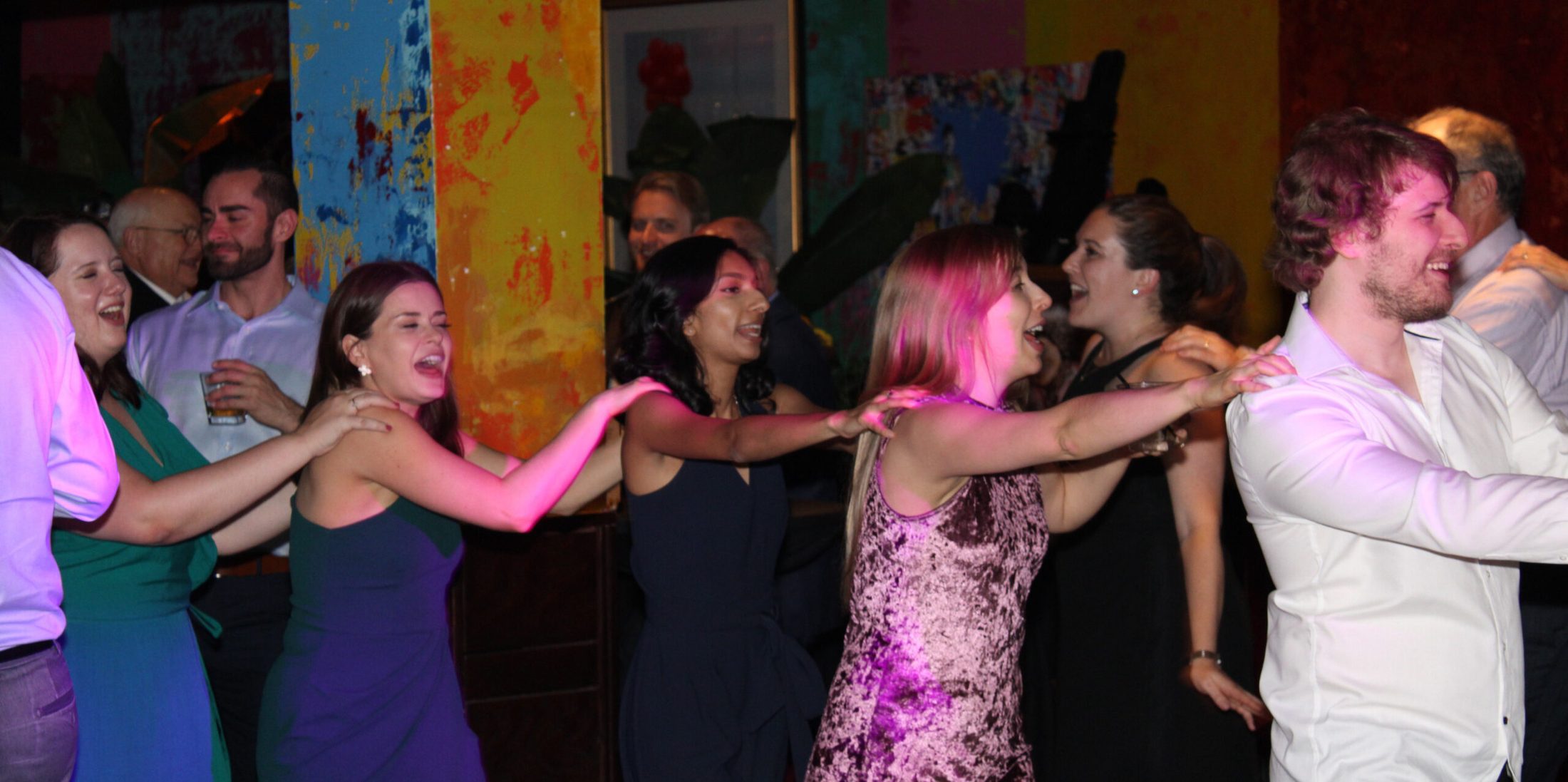 Guests participating in a conga line, dancing to music provided by Paul Michaels Events DJ Company, at Carnivale in Chicago, Illinois