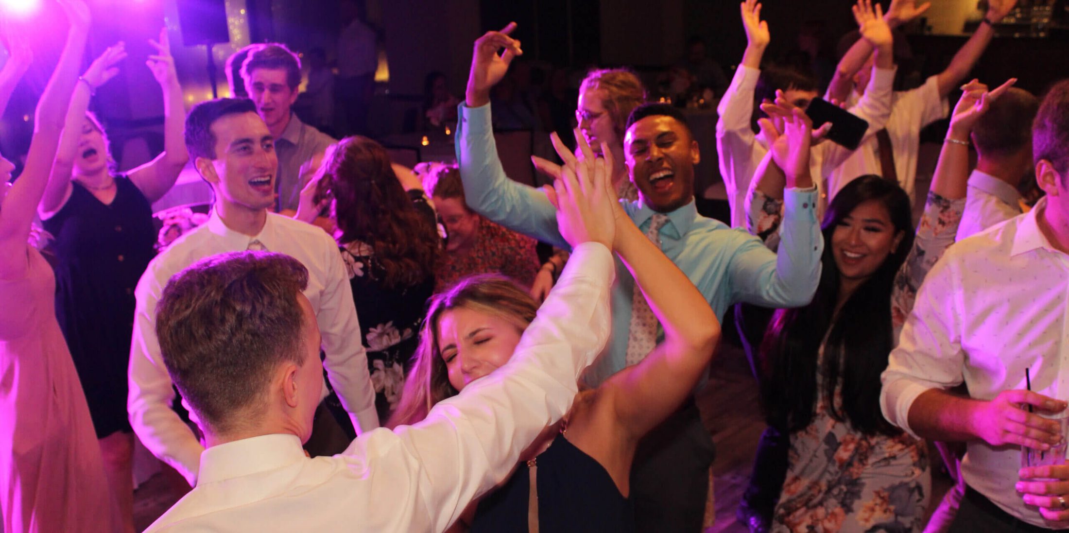 Guests on the dance floor with hands up in the air, dancing to wedding DJ services Chicagoland by Paul Michaels Events