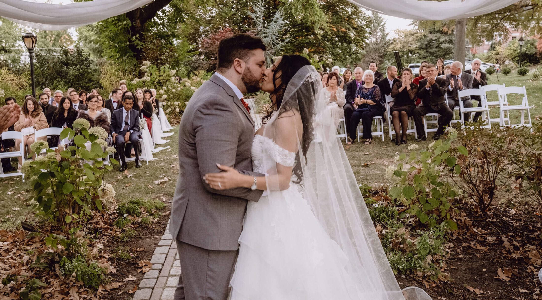 Photo of groom and bride exchanging their first kiss at the altar, with traveling wedding DJ services by Paul Michaels Events