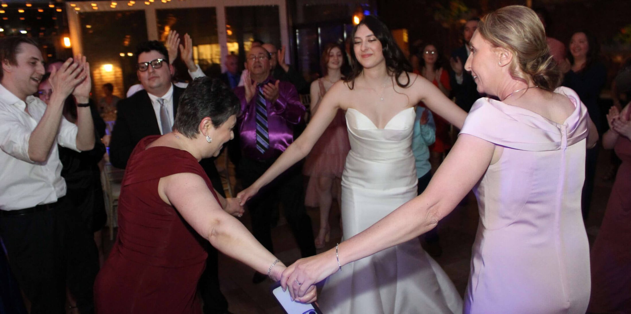 Bride dancing with female family members to music by a Chicago DJ for Downtown Wedding, Paul Michaels Events