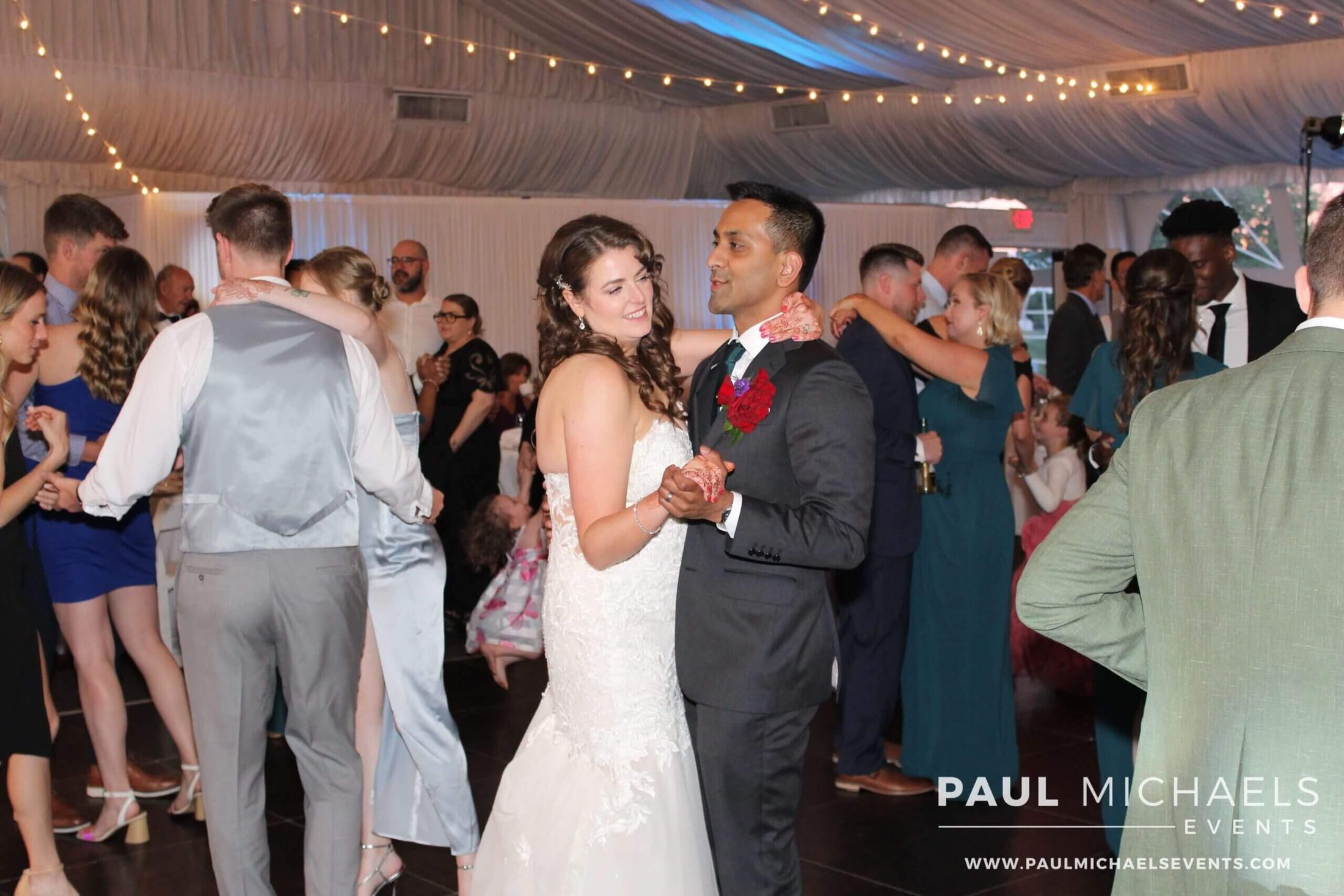 Bride and groom dancing in the middle of their dance floor with other couples dancing around them, with renowned wedding DJ services by Paul Michaels Events being provided