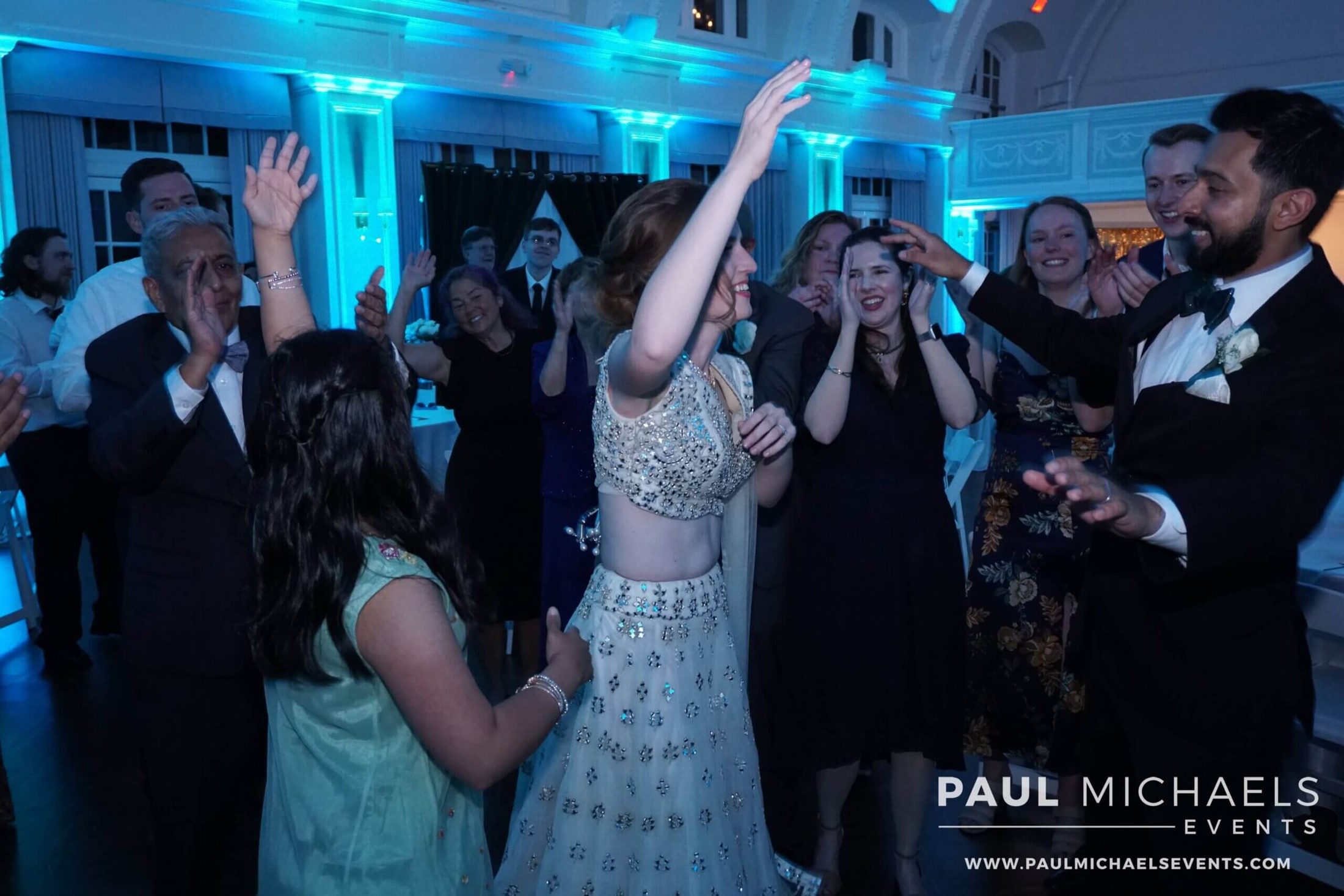 Bride and groom surrounded by loved ones on the dance floor, dancing the night away to the best Evanston DJ entertainment services, courtesy of Paul Michaels Events