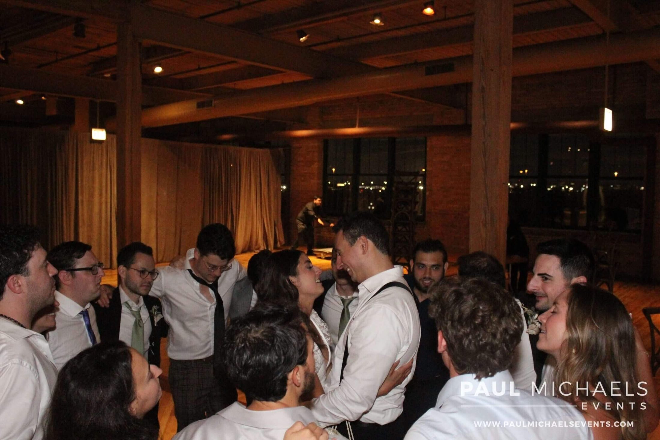 Bride and groom standing in a circle of their loved ones on the dance floor, swaying to the sounds of Paul Michaels Events, a premier Chicago DJ company