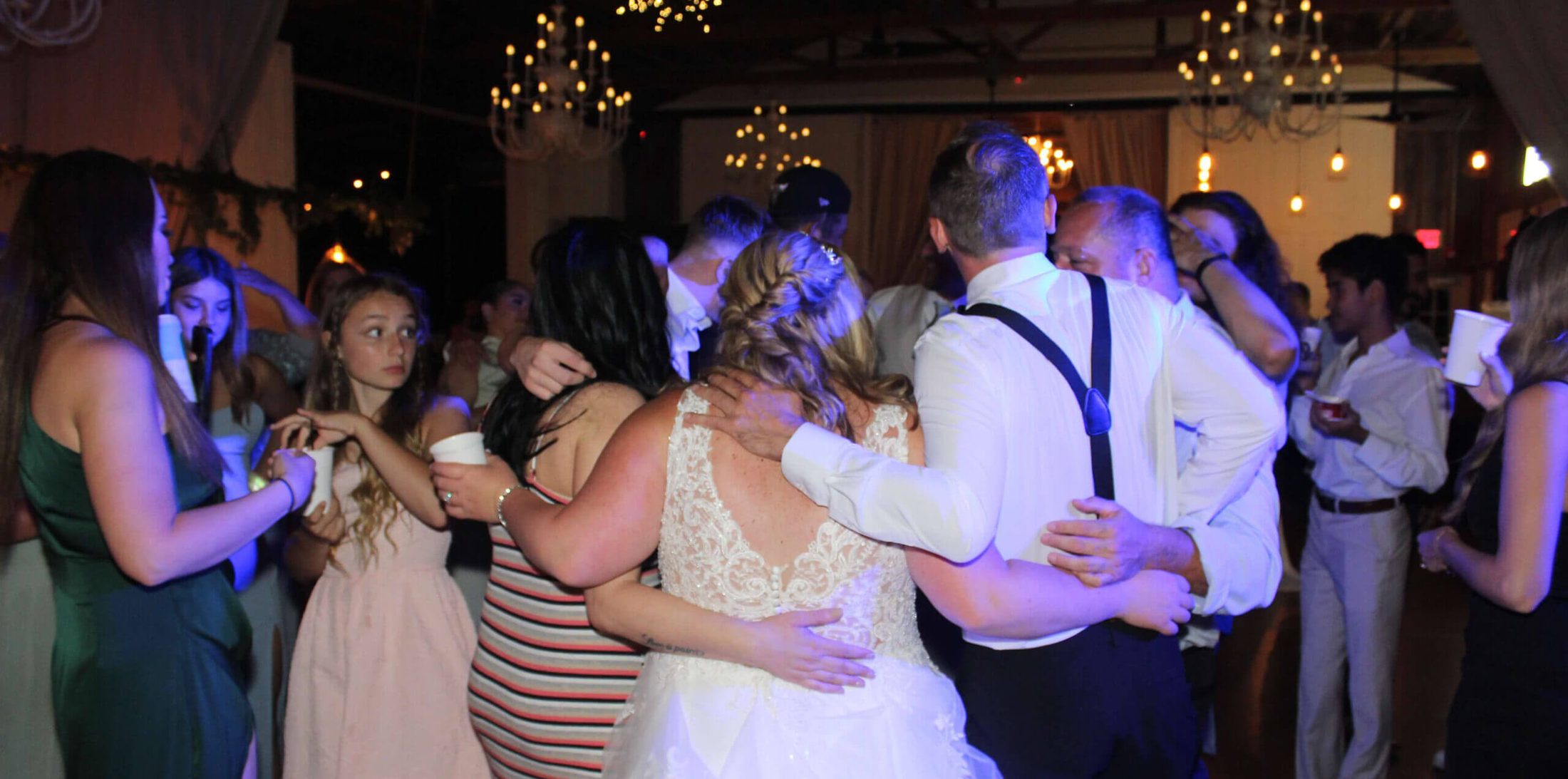 A group circle formed with a bride and groom forming part of the circle, swaying to the sounds of the best Illinois wedding entertainment DJ, Paul Michaels Events
