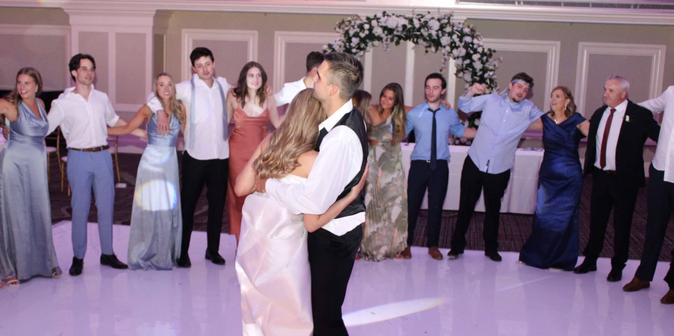 Bride and groom surrounded by friends and family at their wedding