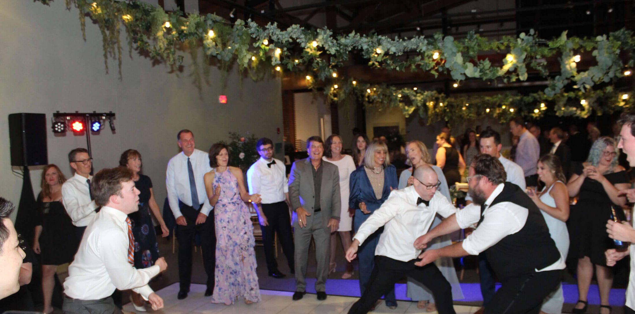 A group of wedding guests dancing on the floor