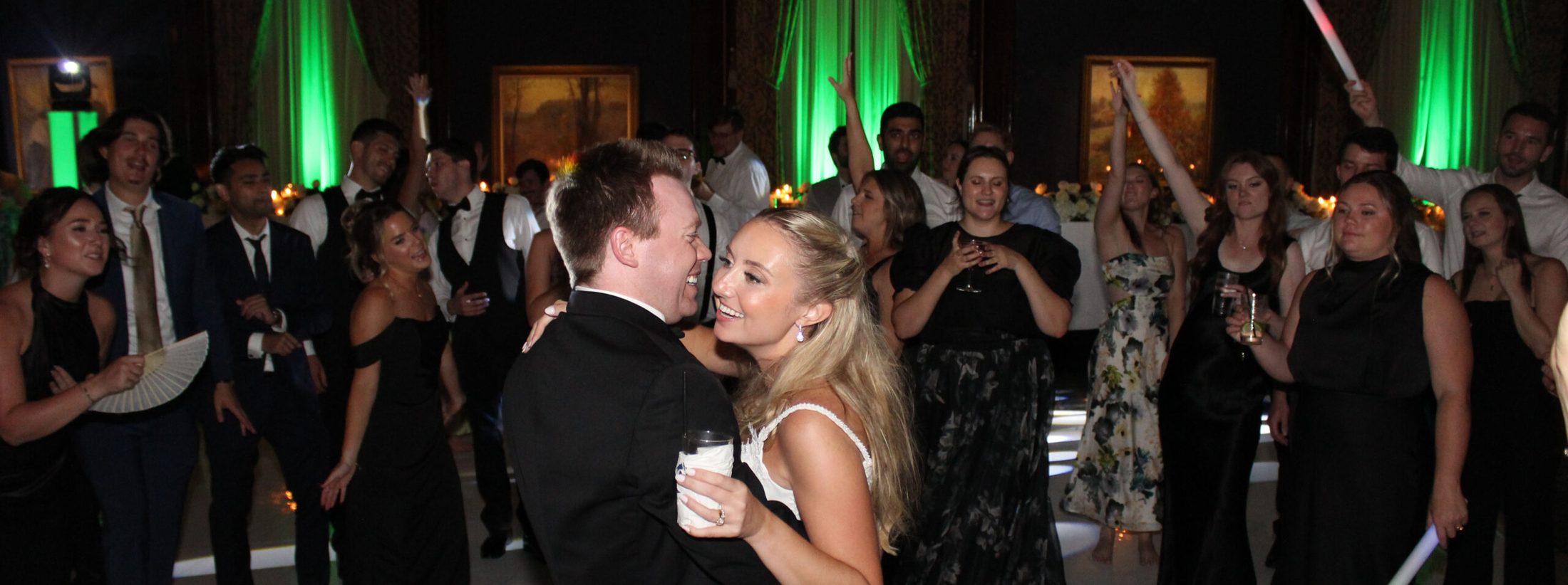 Bride & groom on dance floor surrounded by loved ones