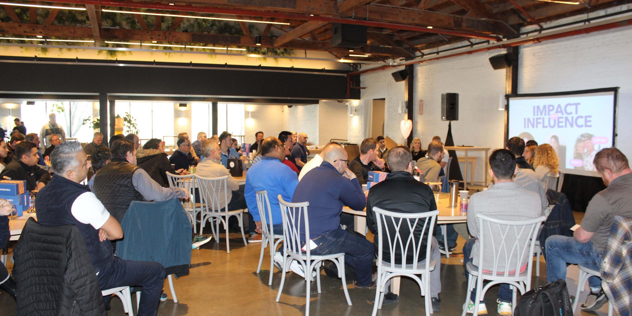 Group of people seated at tables for a meeting.
