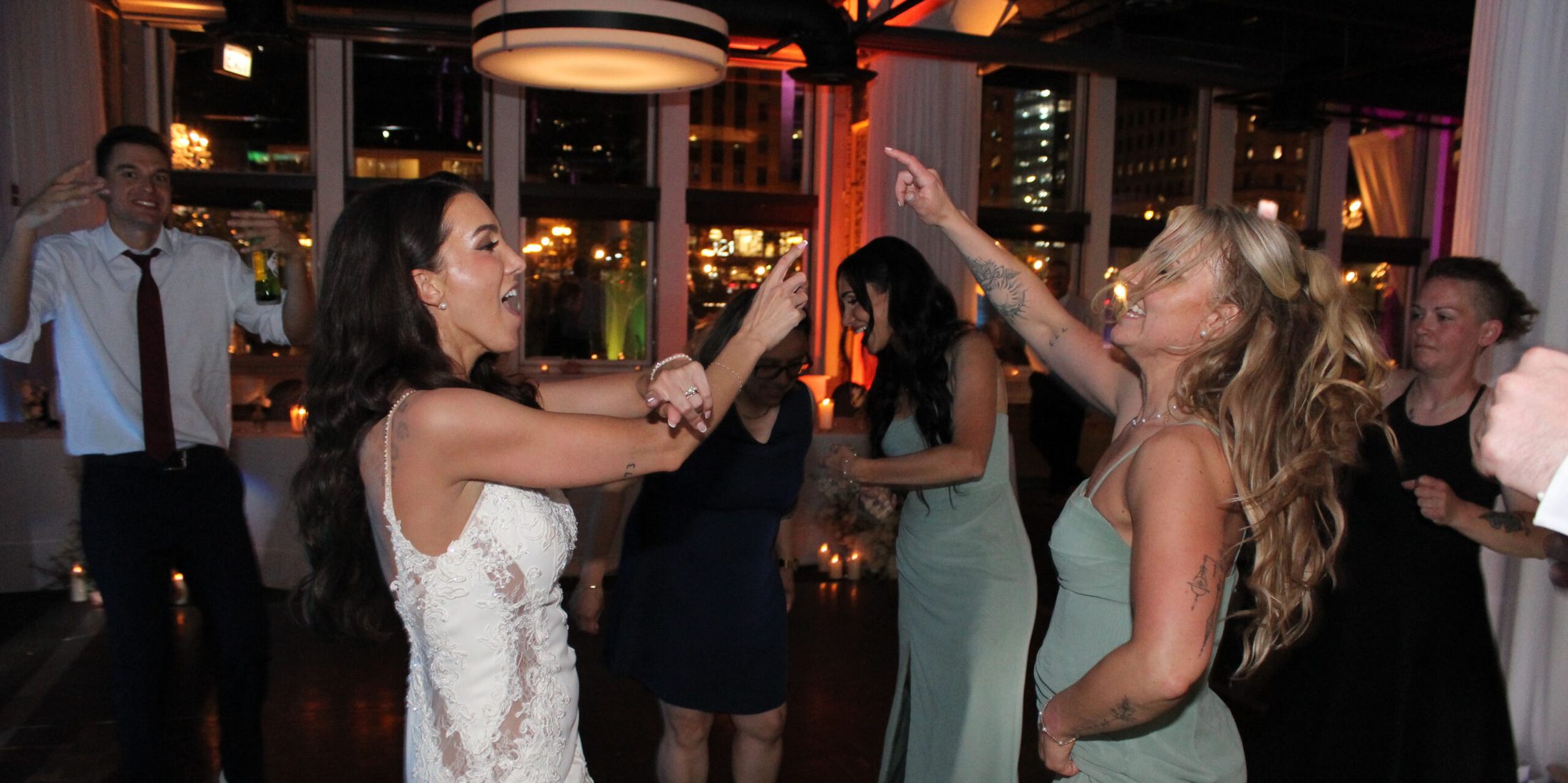 Bride and bridesmaid dancing to music on the dance floor
